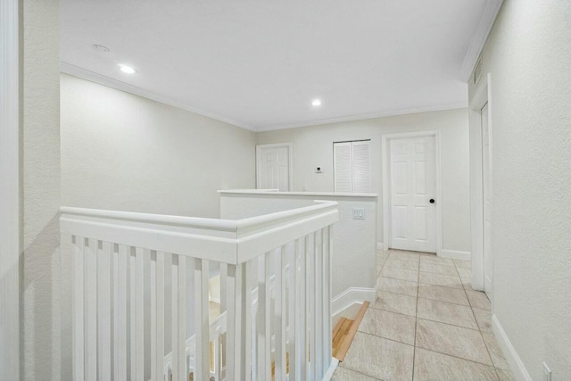 hall with light tile patterned floors and ornamental molding