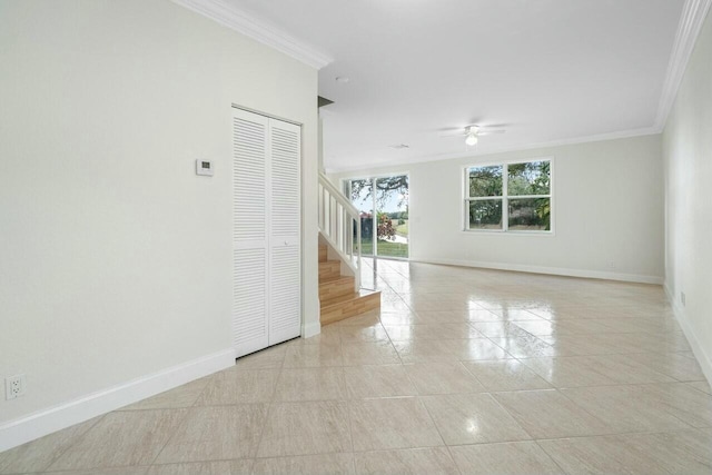 empty room with ceiling fan, crown molding, and light tile patterned flooring