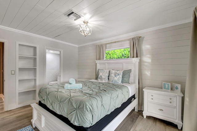 bedroom with wood walls, dark hardwood / wood-style flooring, and ornamental molding