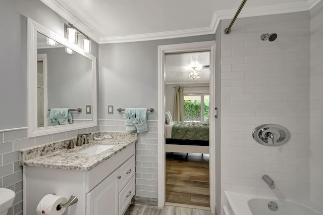 full bathroom with crown molding, wood-type flooring, tile walls, and tiled shower / bath