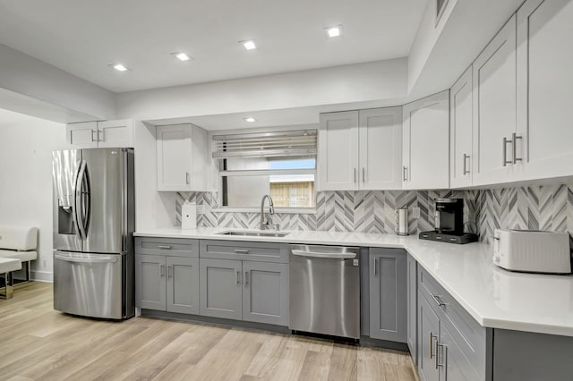 kitchen with gray cabinetry, sink, and stainless steel appliances