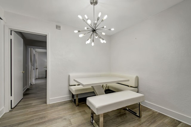 dining room featuring light wood-type flooring and an inviting chandelier