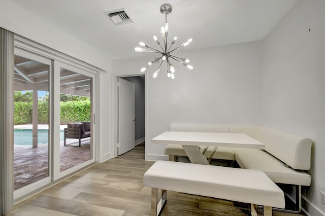 dining room with light hardwood / wood-style flooring and an inviting chandelier