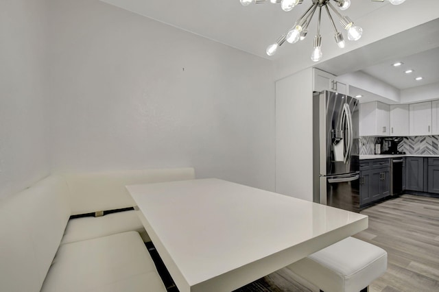 kitchen featuring decorative backsplash, gray cabinets, appliances with stainless steel finishes, light hardwood / wood-style floors, and white cabinetry