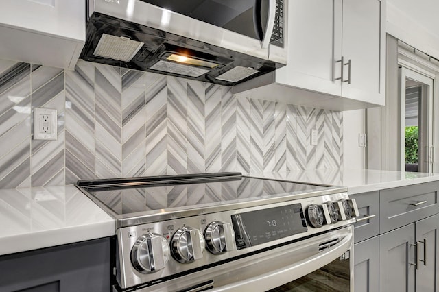 kitchen featuring stainless steel appliances, tasteful backsplash, and gray cabinetry