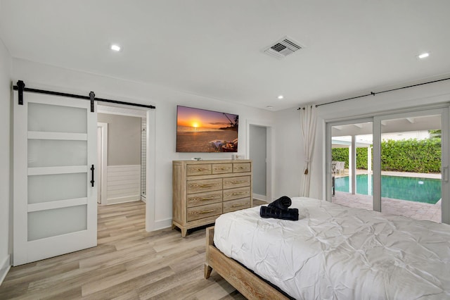 bedroom with access to outside, a barn door, and light hardwood / wood-style floors