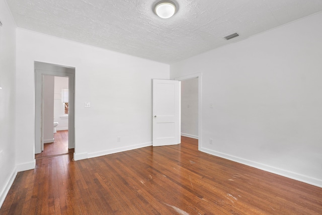 spare room with dark wood-type flooring and a textured ceiling