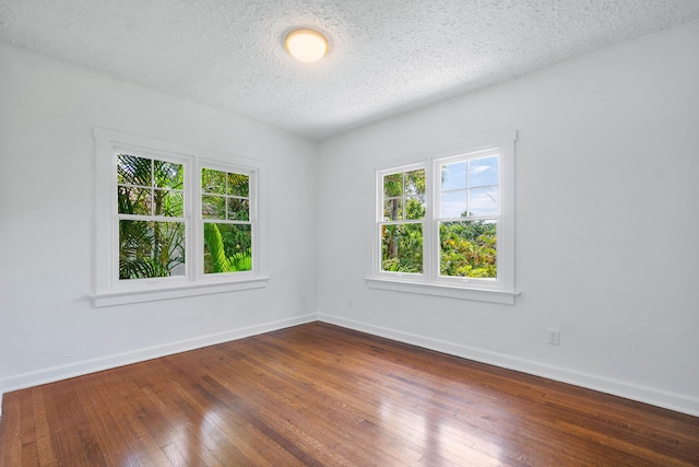 unfurnished room featuring wood-type flooring and a textured ceiling