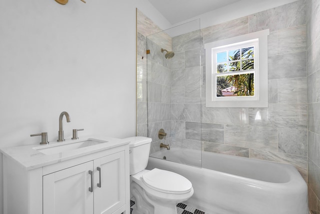 full bathroom featuring vanity, tiled shower / bath combo, and toilet