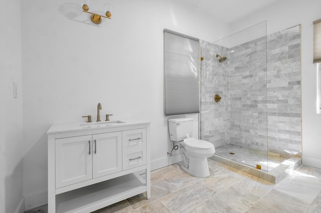 bathroom featuring a tile shower, vanity, and toilet