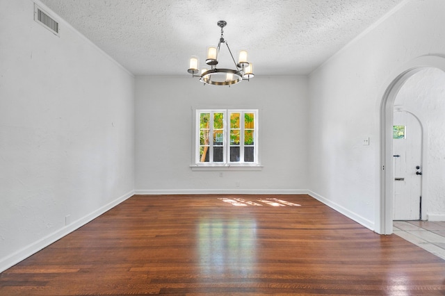 interior space featuring a textured ceiling, dark wood-type flooring, and a chandelier