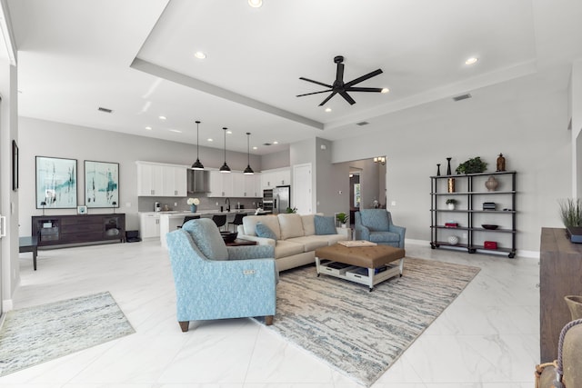 living room featuring a tray ceiling and ceiling fan