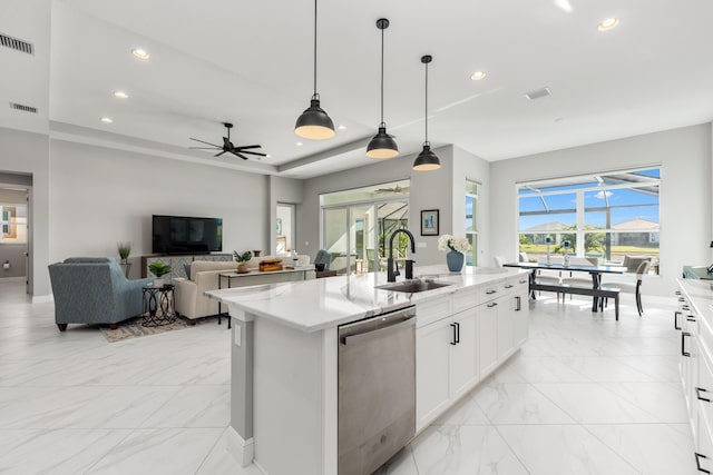 kitchen with stainless steel dishwasher, sink, pendant lighting, white cabinets, and an island with sink