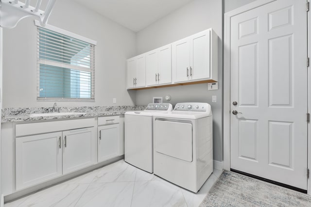 washroom with cabinets, washer and clothes dryer, and sink