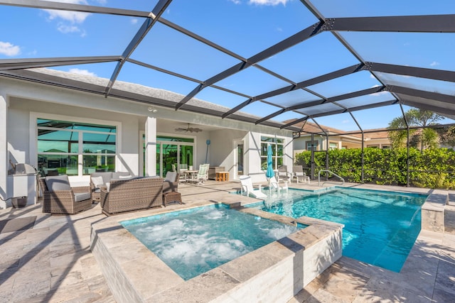 view of swimming pool featuring glass enclosure, pool water feature, ceiling fan, an in ground hot tub, and a patio