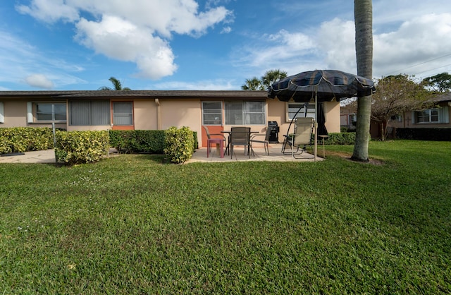 rear view of property with a lawn and a patio