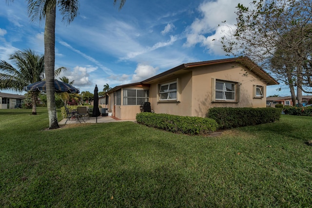 view of side of property with a yard and a patio