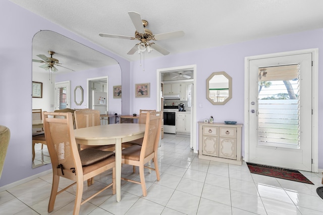 tiled dining area featuring a textured ceiling and ceiling fan