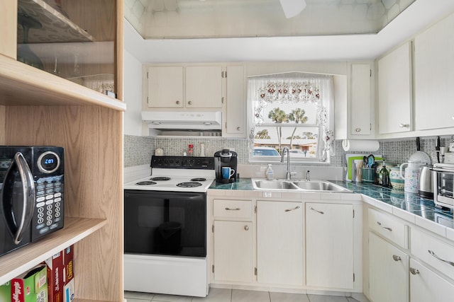 kitchen featuring white range with electric stovetop, decorative backsplash, light tile patterned floors, and sink