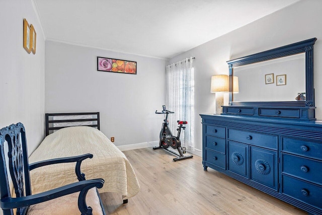 bedroom featuring ornamental molding and light hardwood / wood-style flooring