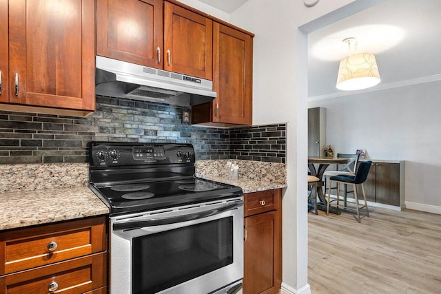 kitchen with light stone counters, light hardwood / wood-style flooring, crown molding, and stainless steel range with electric stovetop