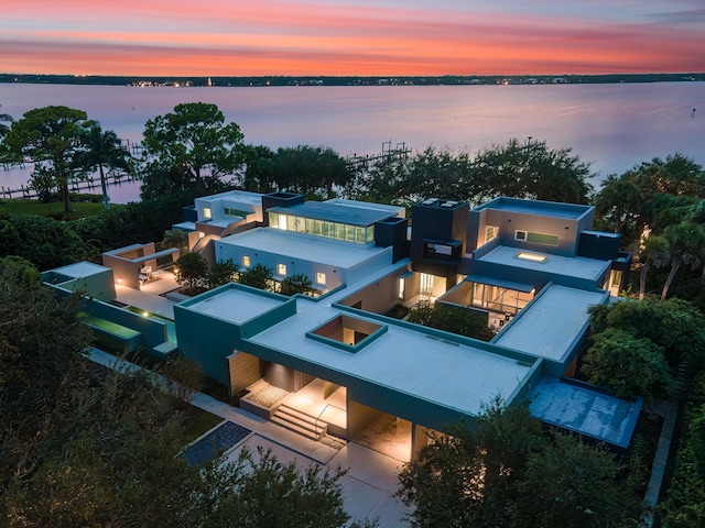 aerial view at dusk featuring a water view