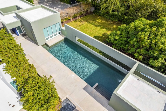 view of swimming pool featuring a yard