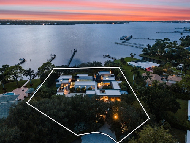 aerial view at dusk featuring a water view