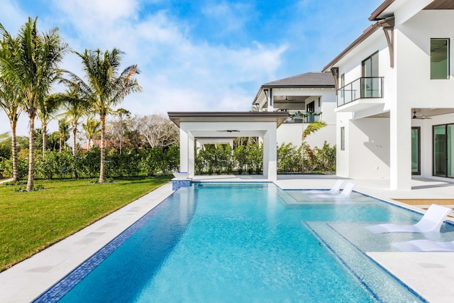 view of swimming pool with a patio, a yard, and ceiling fan