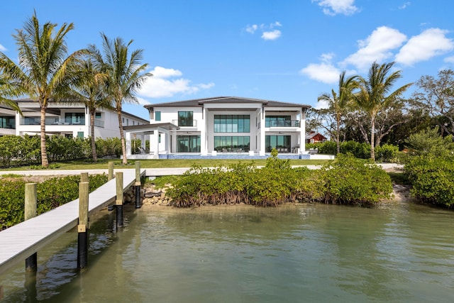 rear view of property featuring a balcony and a water view