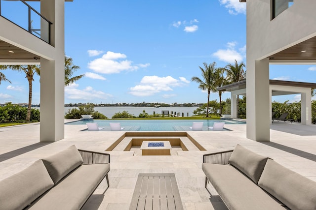 view of pool featuring a patio area, an outdoor living space with a fire pit, and a water view