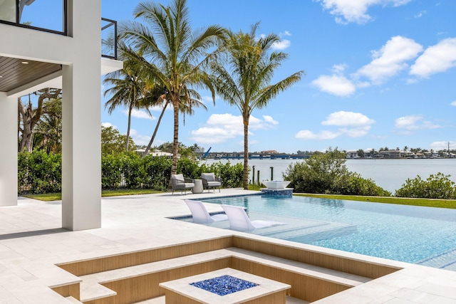 view of pool featuring a fire pit, a patio area, and a water view