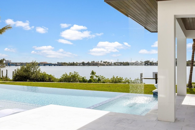 view of swimming pool featuring a yard, a patio, and a water view