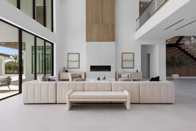 living room with a high ceiling and a large fireplace