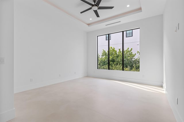 unfurnished room featuring ceiling fan and a raised ceiling