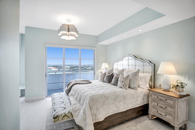 carpeted bedroom featuring access to exterior, a water view, and a notable chandelier