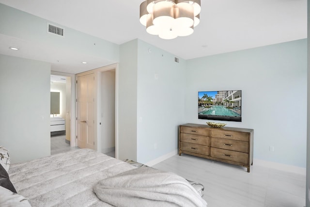 bedroom featuring connected bathroom and an inviting chandelier