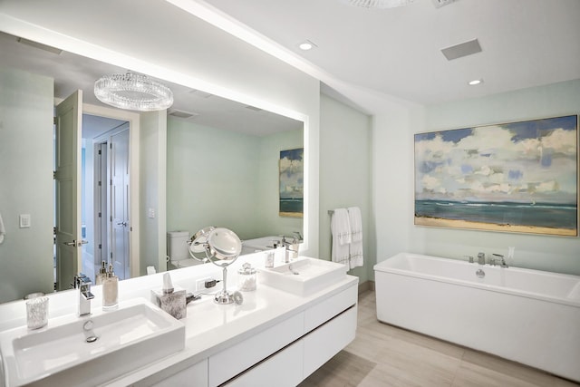 bathroom with wood-type flooring, vanity, toilet, and a bathtub