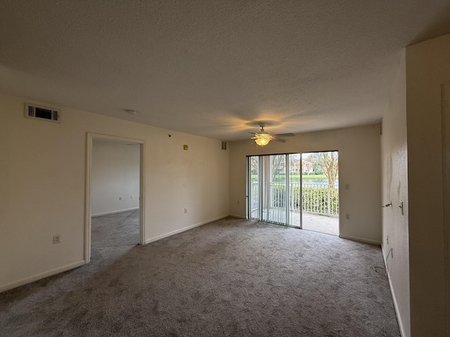 carpeted empty room featuring ceiling fan and a textured ceiling