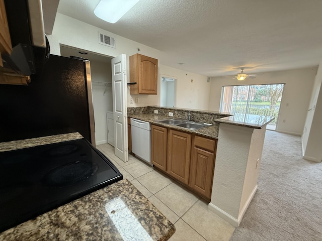 kitchen featuring stainless steel refrigerator, sink, kitchen peninsula, stove, and white dishwasher