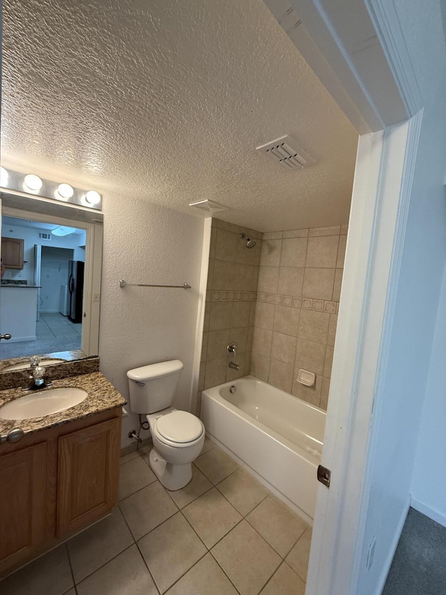 full bathroom featuring tile patterned floors, vanity, toilet, and tiled shower / bath combo