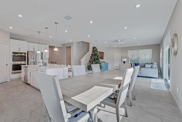 dining space with ceiling fan and sink