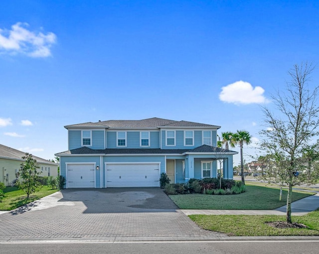 view of front of home with a garage and a front lawn