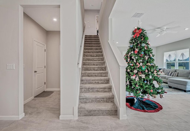 stairway featuring ceiling fan