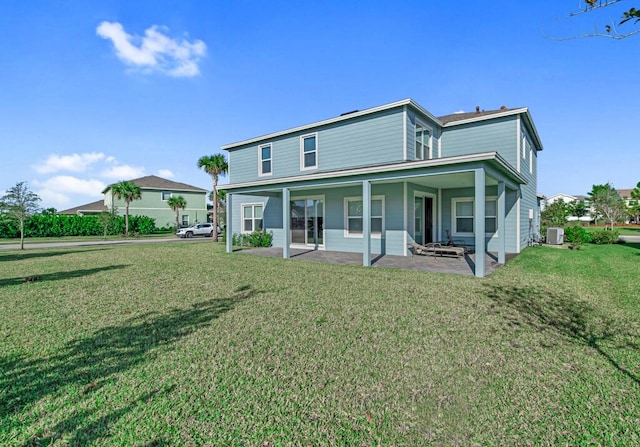 back of property with a lawn and a patio