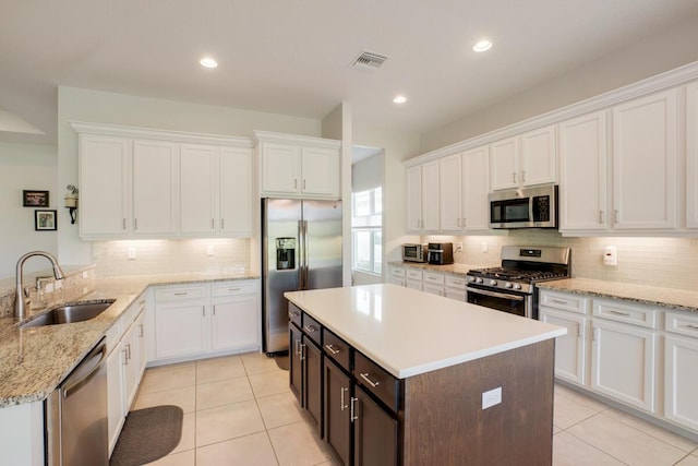 kitchen with appliances with stainless steel finishes, white cabinetry, and sink