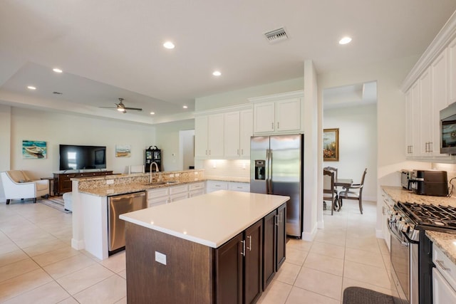 kitchen with ceiling fan, sink, tasteful backsplash, kitchen peninsula, and appliances with stainless steel finishes