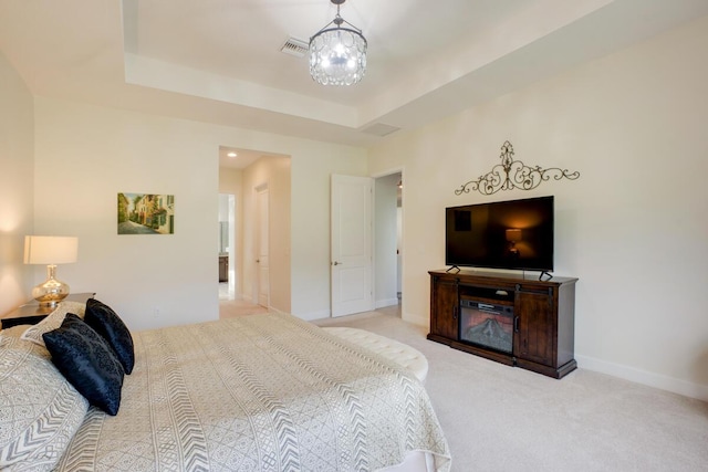 bedroom with light carpet and a tray ceiling