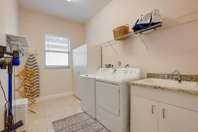 washroom featuring independent washer and dryer, light tile patterned floors, and sink