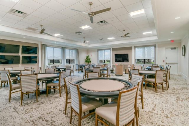 dining area with a paneled ceiling, a wealth of natural light, and light carpet